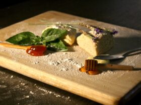 Beautifully plated blackberry basil ricotta pizza with fresh herbs and drizzled balsamic glaze on rustic wooden board