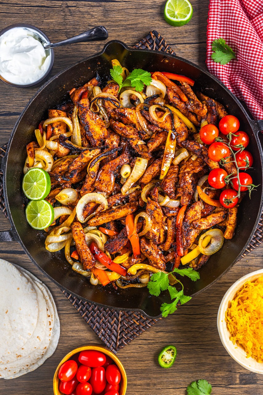 Step-by-step shots showing chicken browning in skillet and chipotle peppers being added to create the signature tinga sauce