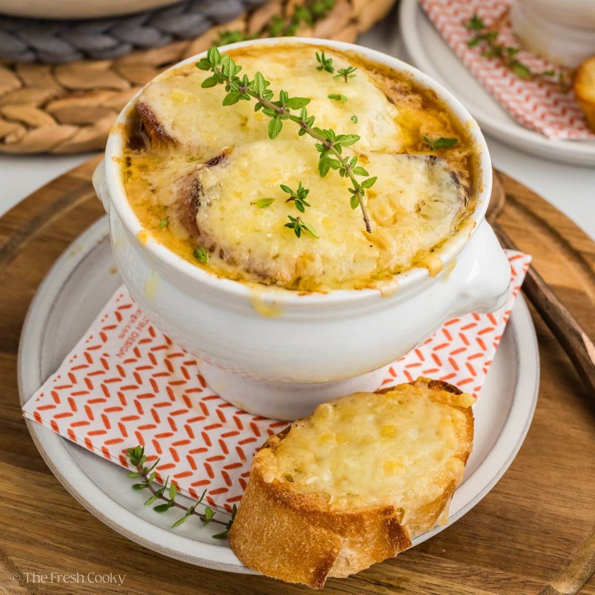 Close-up of French onion soup showing layers of melted cheese, caramelized onions, and rich broth with crusty bread