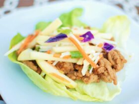 Hoisin turkey lettuce wraps arranged on white platter with garnishes