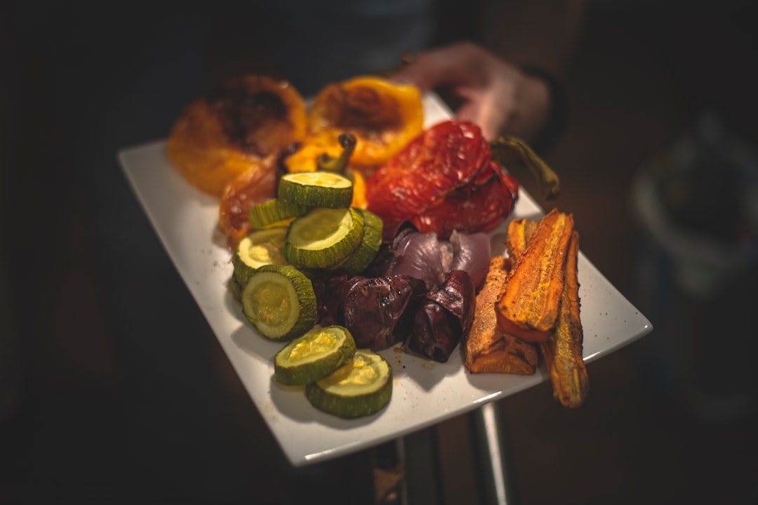 raw beef chunks being seared in instant pot with vegetables prepped in background