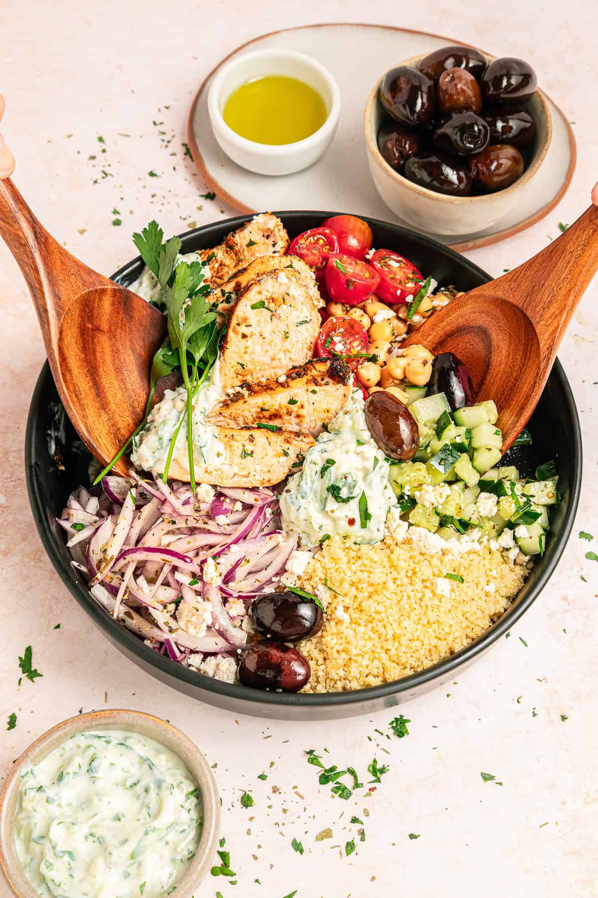 Mediterranean chicken bowl with golden seasoned chicken, fresh vegetables, olives, feta cheese, and creamy tzatziki arranged in a rustic ceramic bowl