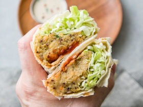 Trader Joe's style spicy lentil wrap cut in half showing colorful filling with lentils and vegetables on rustic wooden board