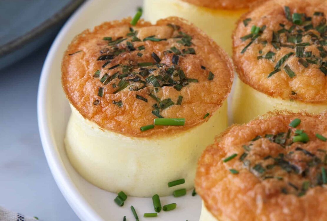 Fluffy homemade Starbucks egg bites arranged on a white plate with fresh herbs, golden and perfectly cooked