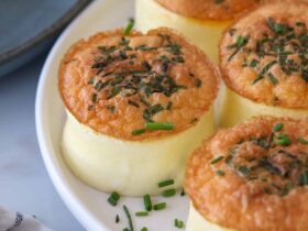 Fluffy homemade Starbucks egg bites arranged on a white plate with fresh herbs, golden and perfectly cooked