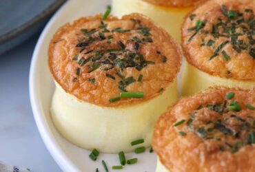 Fluffy homemade Starbucks egg bites arranged on a white plate with fresh herbs, golden and perfectly cooked