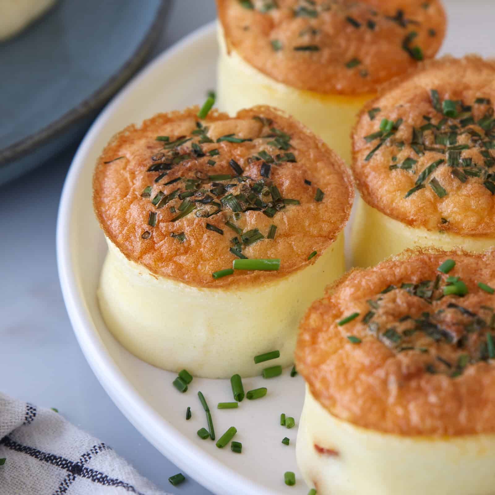 Fluffy homemade Starbucks egg bites arranged on a white plate with fresh herbs, golden and perfectly cooked