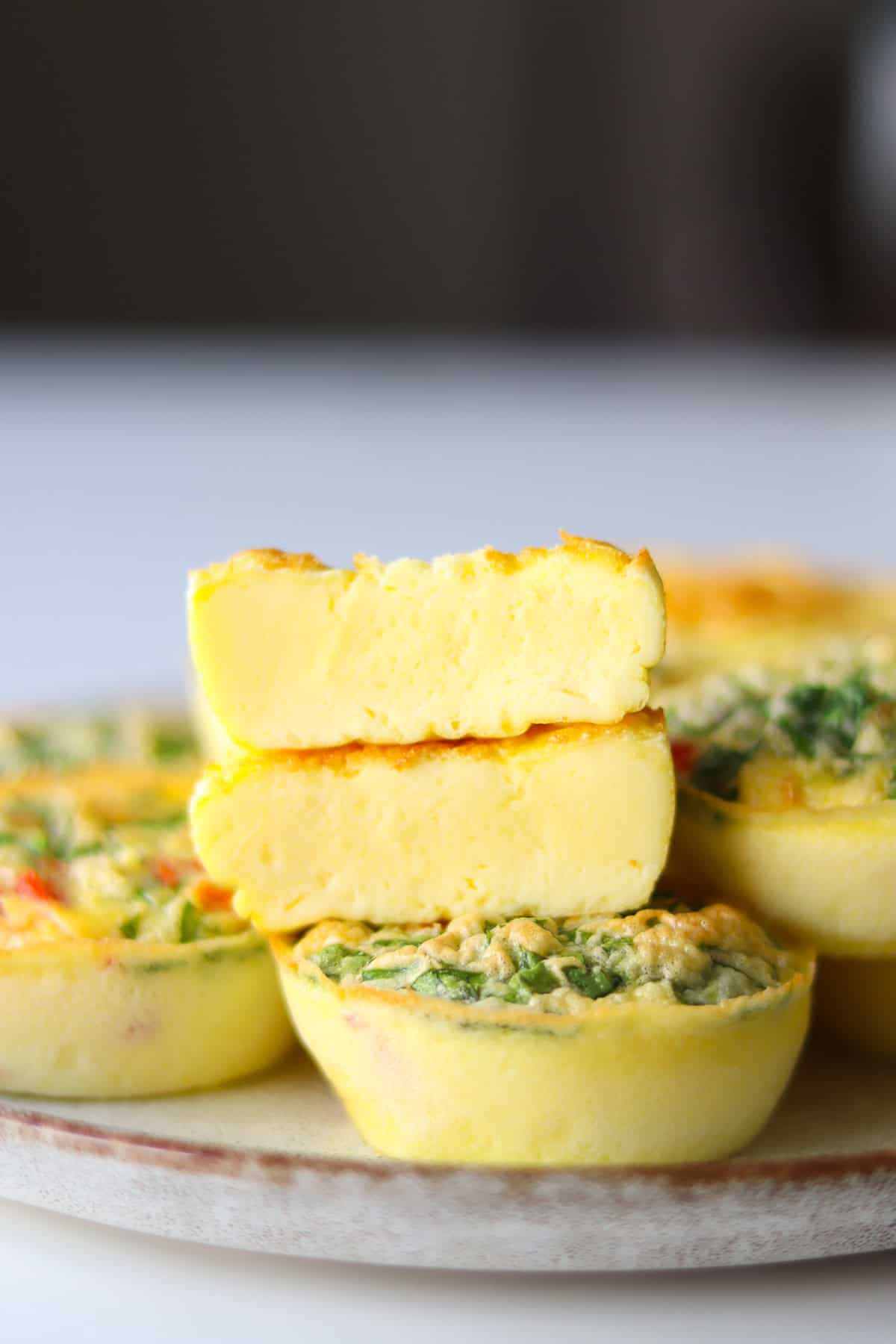 Close-up of a perfectly fluffy egg bite cut in half showing the creamy interior with visible cheese and herbs