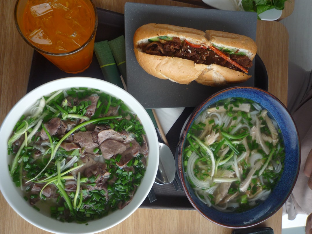 Colorful banh mi sandwiches with crispy bread, pickled vegetables, fresh herbs, and golden protein filling arranged on a wooden cutting board