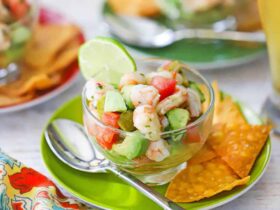 Fresh shrimp ceviche served in a large glass bowl with colorful diced vegetables, garnished with cilantro and served with tortilla chips