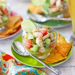 Fresh shrimp ceviche served in a large glass bowl with colorful diced vegetables, garnished with cilantro and served with tortilla chips