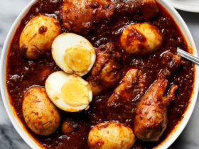 Ethiopian Doro Wat served in a traditional clay pot with hard-boiled eggs visible, garnished with fresh herbs, with injera bread on the side