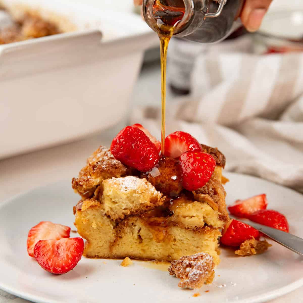 Step-by-step prep shots showing cubed bread in baking dish and custard mixture being poured over, ingredients laid out on marble counter