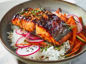 Beautifully plated miso glazed salmon with caramelized golden glaze on white plate with steamed rice and vegetables