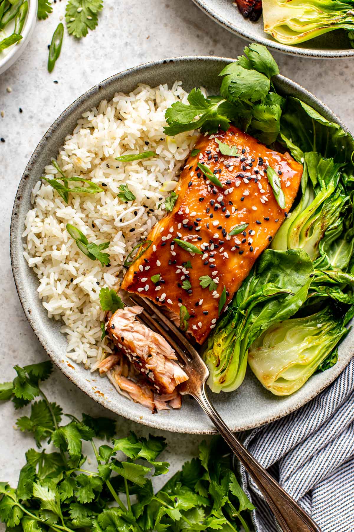 Close-up shot of sliced miso glazed salmon showing the caramelized exterior and flaky pink interior, garnished with sesame seeds and scallions