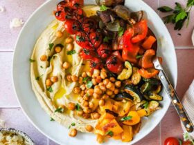 Roasted chickpea and vegetable hummus bowl beautifully plated with creamy hummus, crispy golden chickpeas, colorful fresh vegetables, and a drizzle of olive oil