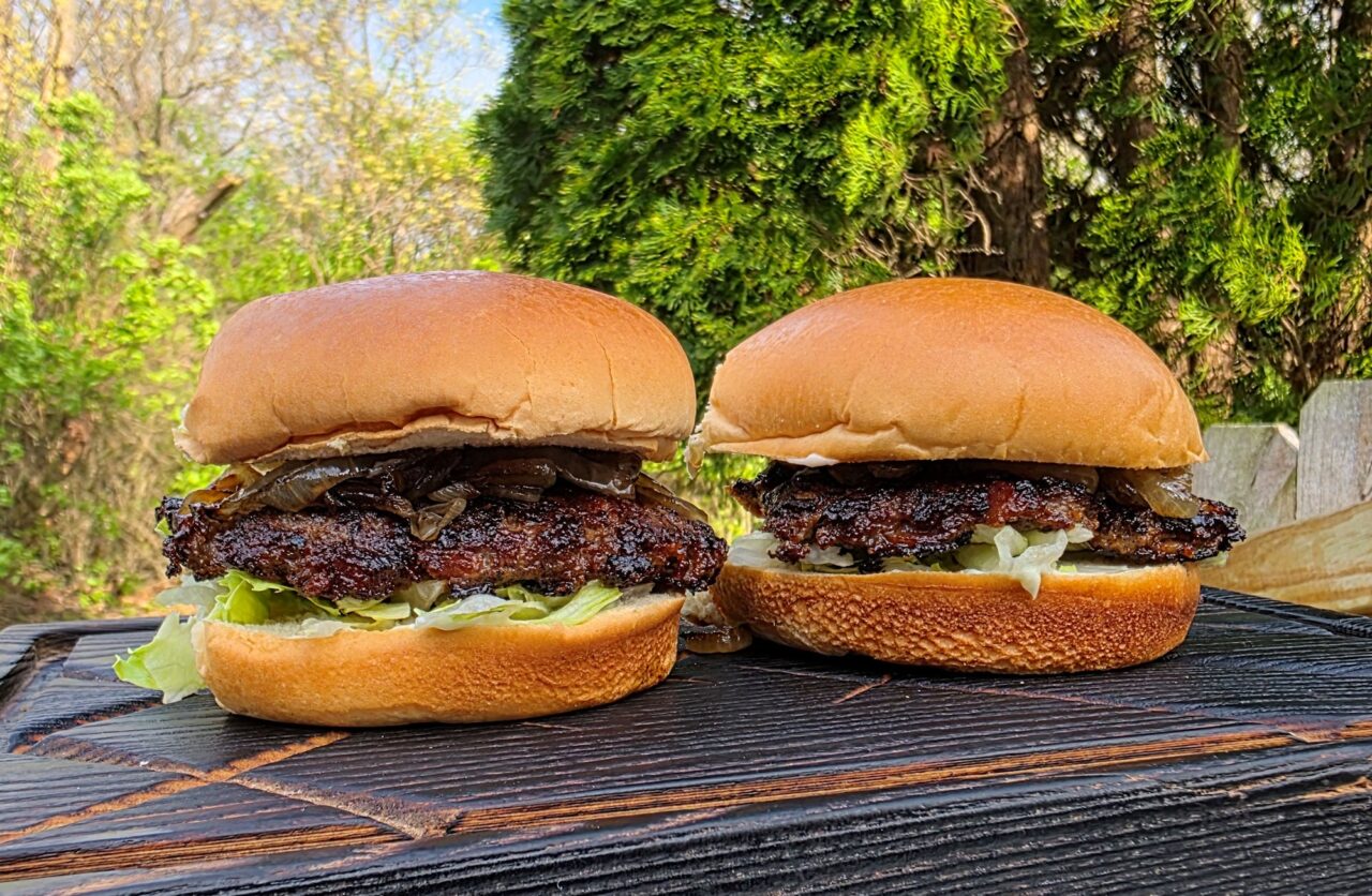 Step-by-step ingredients flat lay showing ground beef, ranch seasoning packet, shredded cheddar, bacon strips, and brioche buns on a marble surface