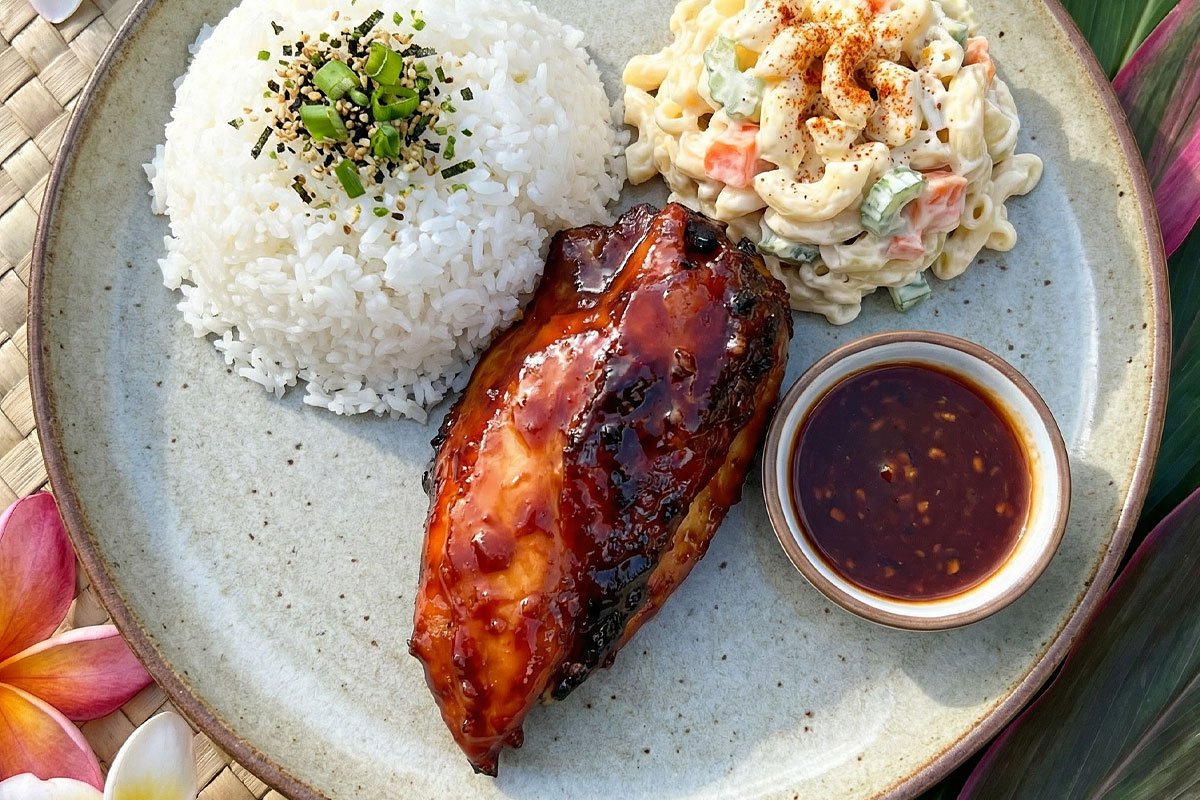 Close-up of Huli Huli Chicken with glossy caramelized pineapple glaze served over white rice with green onions and sesame seeds