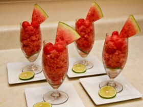 Watermelon lime granita served in a chilled glass bowl with lime wedge and fresh mint garnish on a sun-drenched outdoor table