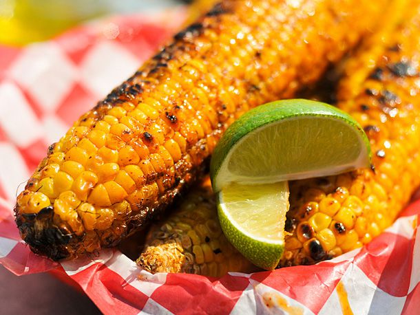 Ingredients for grilled corn on the cob laid out flat — ears of corn, compound butter, Parmesan, lime, chili powder, and garlic