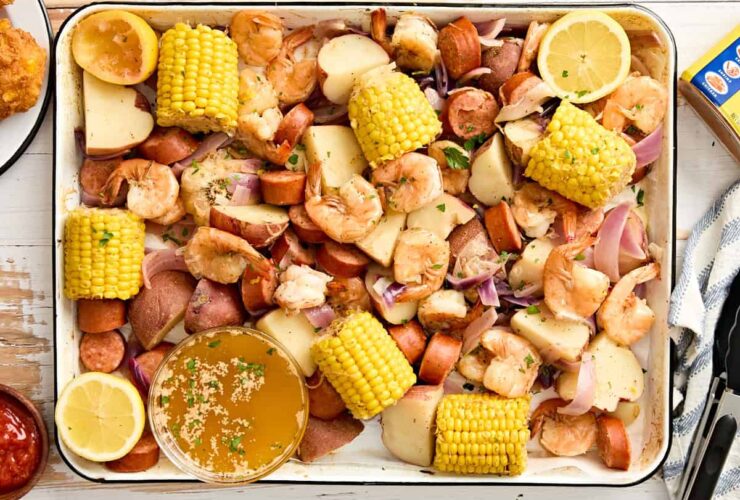 Low Country Shrimp Boil served on a large platter with corn, sausage, potatoes and shrimp garnished with lemon wedges and fresh parsley