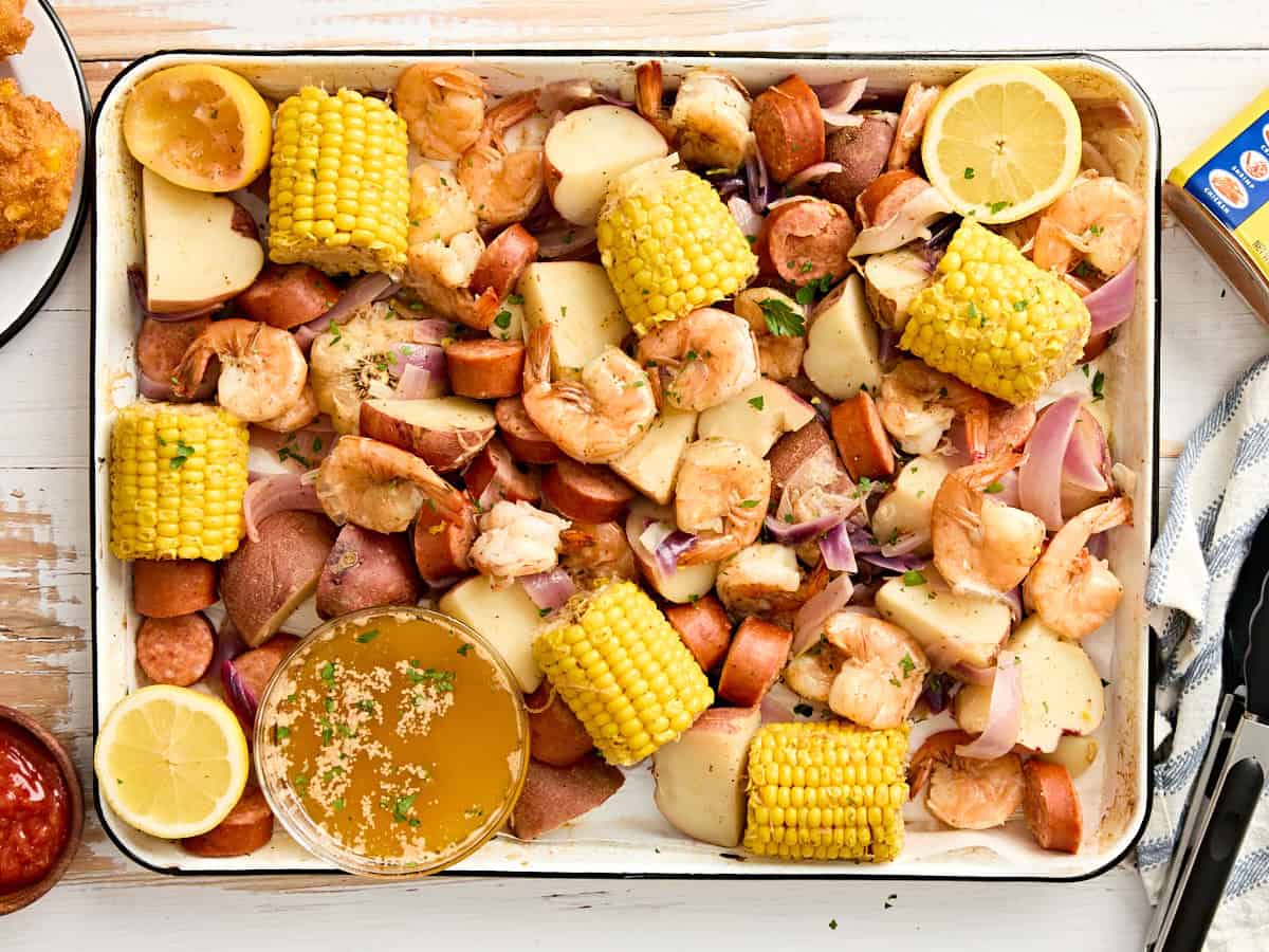 Low Country Shrimp Boil served on a large platter with corn, sausage, potatoes and shrimp garnished with lemon wedges and fresh parsley