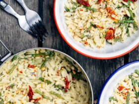 One pot cheesy orzo with asparagus served in a wide shallow bowl, topped with shaved Parmesan and fresh lemon zest, garnished with cracked black pepper, soft natural light
