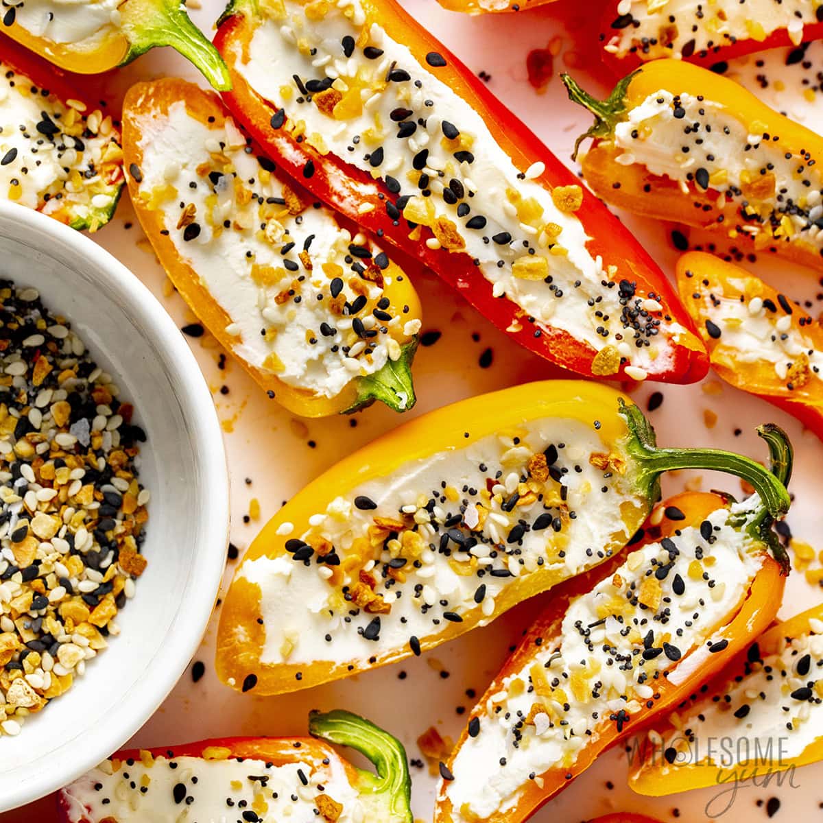 Close-up of a stuffed bell pepper cut in half showing the cheesy ground beef and rice filling, served on a rustic ceramic plate with fresh herbs