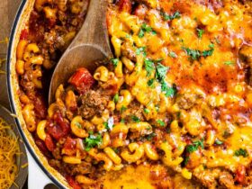 American goulash in a large pot, garnished with fresh parsley, showing tender macaroni and ground beef in a rich tomato sauce
