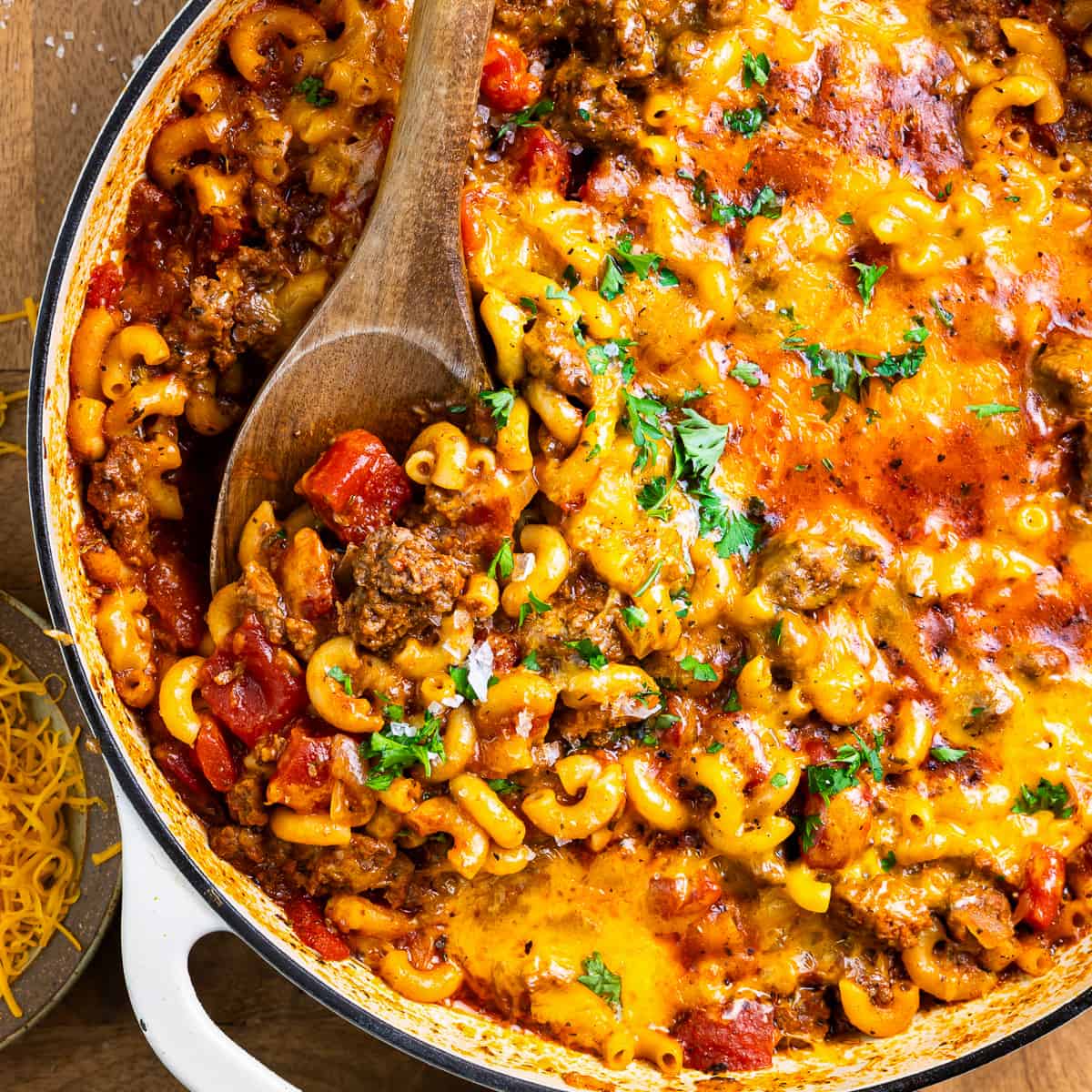 American goulash in a large pot, garnished with fresh parsley, showing tender macaroni and ground beef in a rich tomato sauce